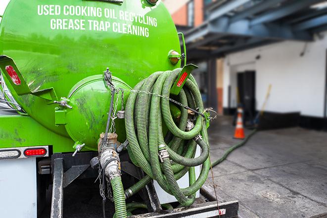 a grease trap pumping service in action at a commercial building in Bloomingdale, GA