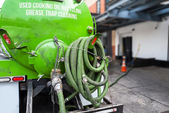 worker pumping grease trap at commercial kitchen in Portal GA